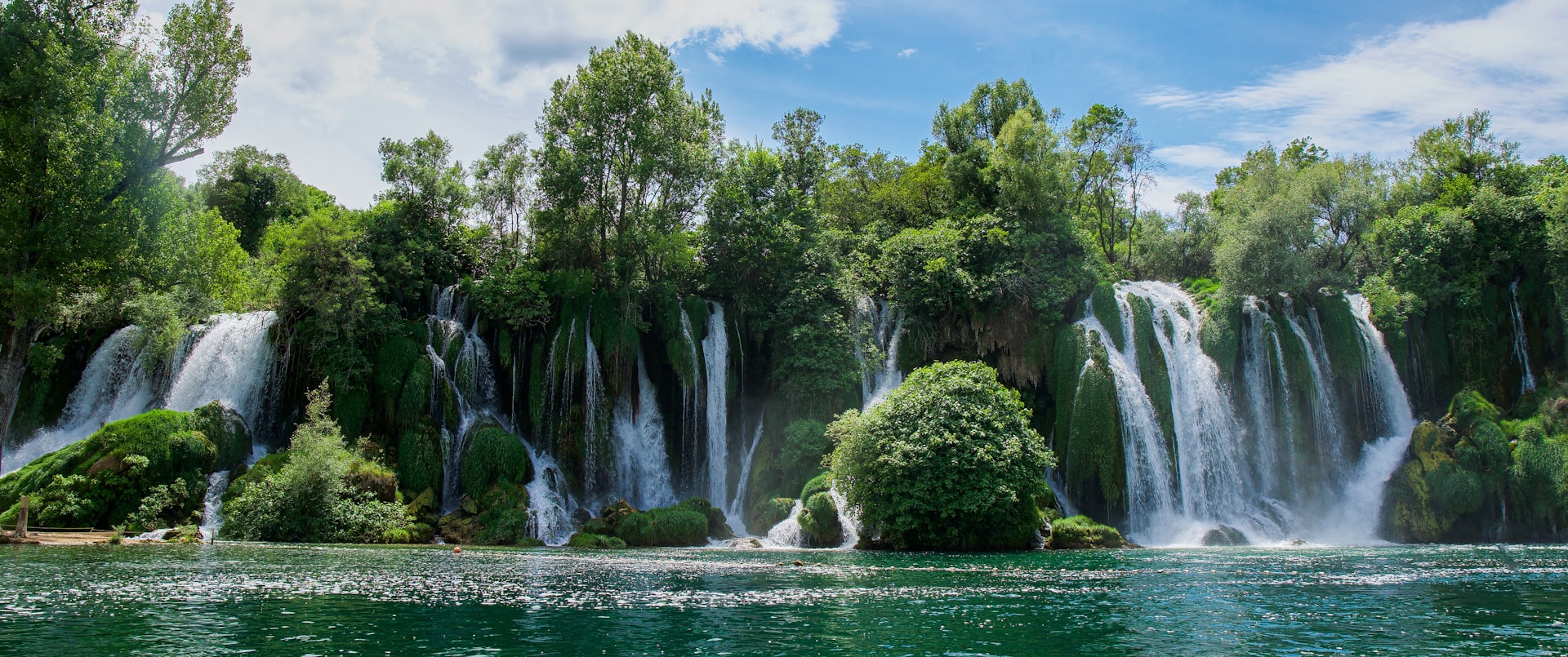 a large waterfall in the middle of a body of water